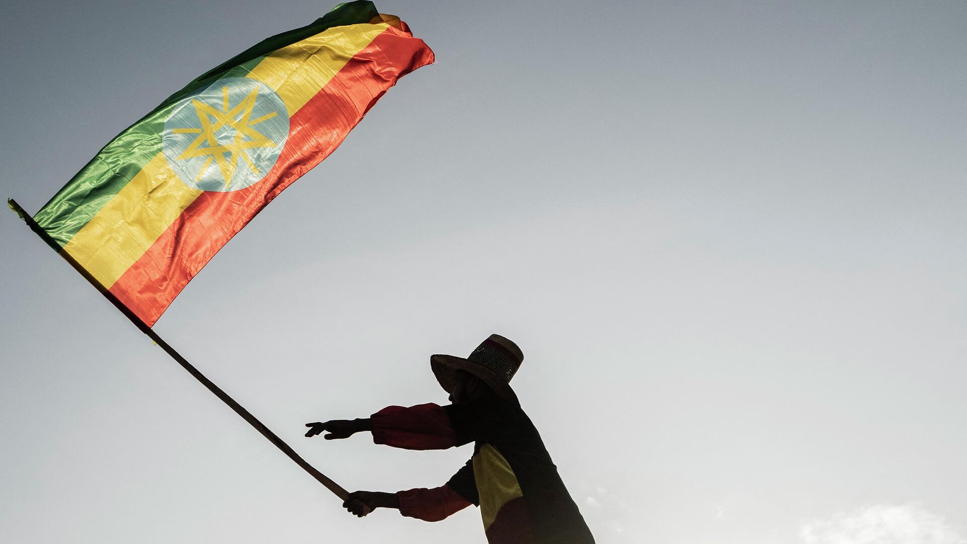 A man waves an Ethiopian flag as he join others gathering in Addis Ababa, Ethiopia, on October 22, 2022 during a demonstration in support of Ethiopia armed forces. - Sputnik Africa, 1920, 24.08.2023
