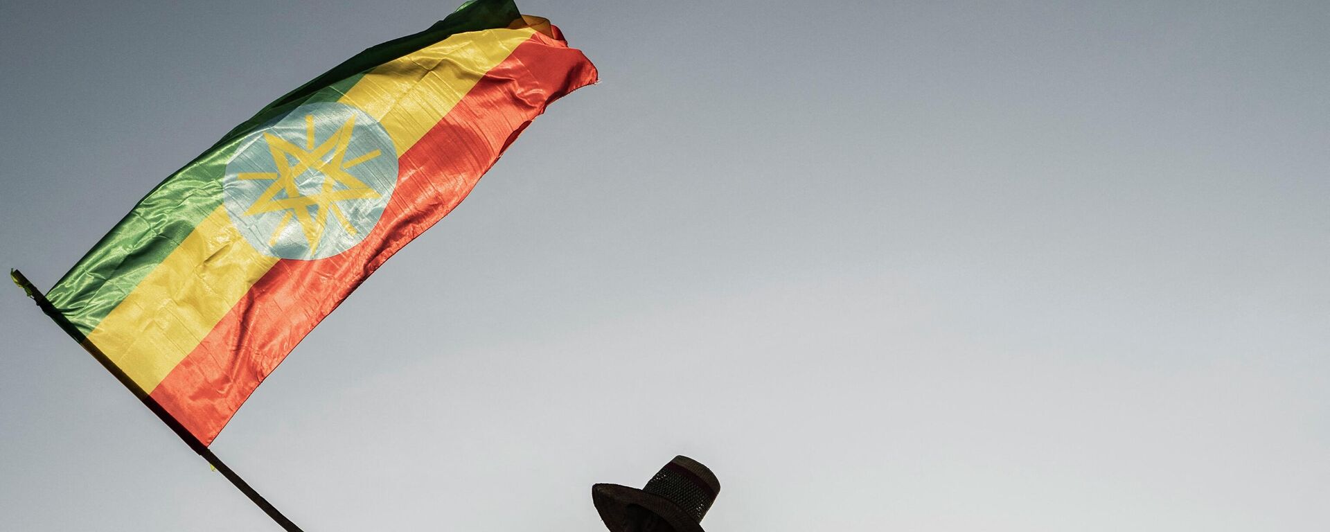 A man waves an Ethiopian flag as he join others gathering in Addis Ababa, Ethiopia, on October 22, 2022 during a demonstration in support of Ethiopia armed forces. - Sputnik Africa, 1920, 26.08.2023