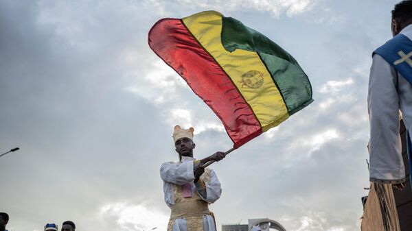 An Orthodox deacon waves an Ethiopian flag during the celebrations in the eve of the Ethiopian Orthodox holiday of Meskel, in Addis Ababa on September 26, 2022.  - Sputnik Africa
