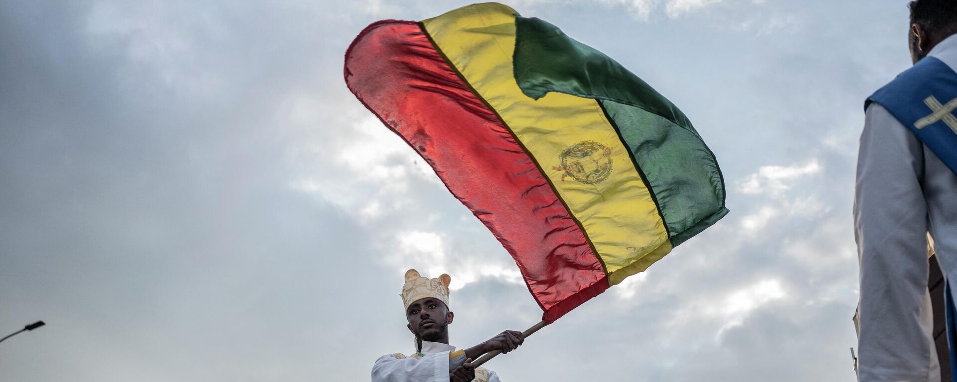An Orthodox deacon waves an Ethiopian flag during the celebrations in the eve of the Ethiopian Orthodox holiday of Meskel, in Addis Ababa on September 26, 2022.  - Sputnik Africa, 1920, 24.08.2023