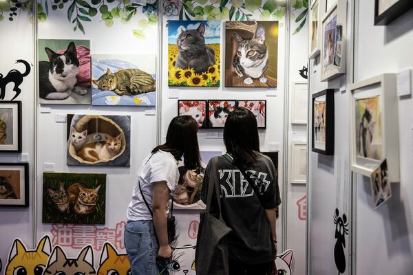 People look at the paintings on display at the Hong Kong Cat Expo on August 25, 2023. - Sputnik Africa