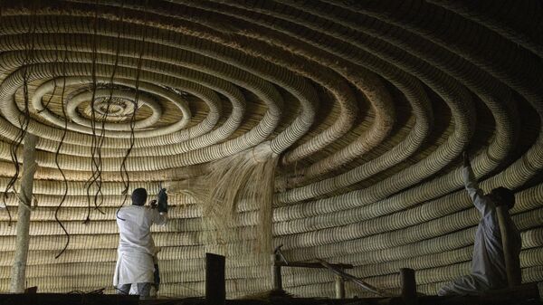 Traditional artisans fix the circular rings at the ceiling of one of the buildings belonging to the Kasubi Royal Tombs in Kampala, Uganda on June 13, 2023. - Sputnik Africa