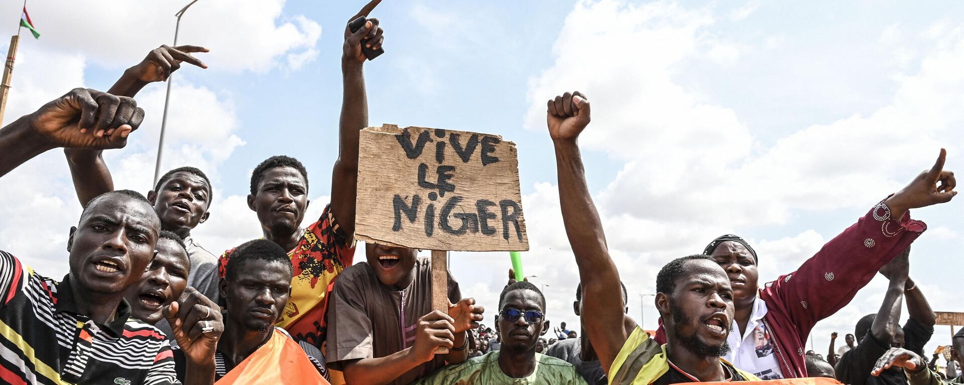 Supporters of the Niger's National Council for the Safeguard of the Homeland (CNSP) wave a placard as they demonstrate ouside the Niger and French airbases in Niamey on August 27, 2023. - Sputnik Africa, 1920, 25.09.2023