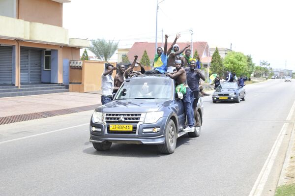 Residents driving in a vehicle celebrate and hold a Gabon national flag in Libreville on August 30, 2023 after a group of Gabonese military officers appeared on television announcing they were &quot;putting an end to the current regime&quot; and scrapping official election results that had handed another term to veteran President Ali Bongo Ondimba. In a pre-dawn address, a group of officers declared &quot;all the institutions of the republic&quot; had been dissolved, the election results cancelled and the borders closed.  - Sputnik Africa