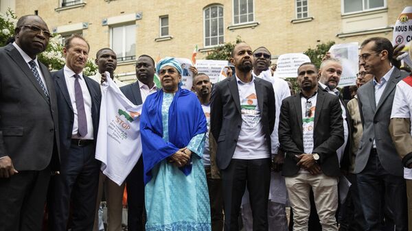 Ousted Prime Minister of Niger Ouhoumoudou Mahamadou, left, and Aichatou Boulama Kane, 5th from left, Ambassador of Niger in Paris, pose with a group of demonstrators gathered in front of the Embassy of Niger in support of Nigerien President Mohamed Bazoum, in Paris Saturday, Aug. 5, 2023. - Sputnik Africa