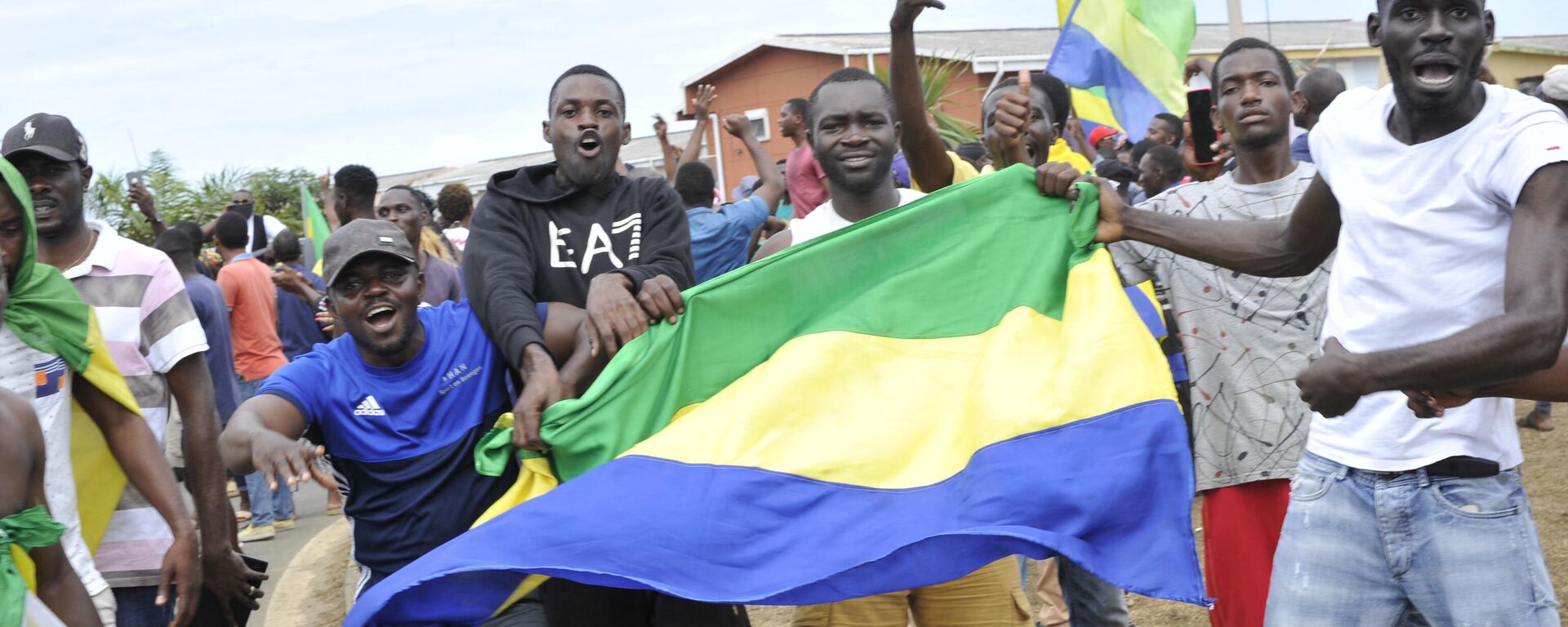 Residents gesture and hold a Gabon national flag in Libreville on August 30, 2023 - Sputnik Africa, 1920, 14.09.2023