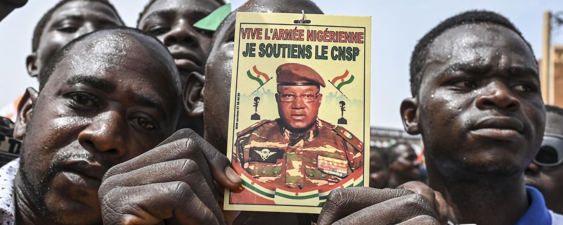 A man holds a placard with the image of Niger's new military ruler General Abdourahamane Tiani on as supporters of Niger's National Council of Safeguard of the Homeland (CNSP) protest outside the Niger and French airbase in Niamey on September 2, 2023 to demand the departure of the French army from Niger. - Sputnik Africa, 1920, 02.09.2023