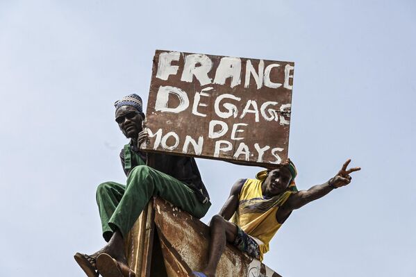 A man burns holds a placard as supporters of Niger&#x27;s National Council of Safeguard of the Homeland (CNSP) protest outside the Niger and French airbase in Niamey on September 2, 2023 to demand the departure of the French army from Niger. - Sputnik Africa