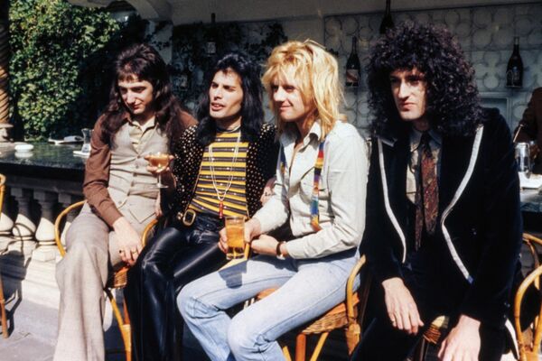 British Rock band &quot;Queen&quot; (from L), John Deacon, Freddie Mercury, Roger Taylor and Brian May pose after receiving a British Phonographic Institute Platinum, Gold and Silver award for record sales in London on September 8, 1976.  - Sputnik Africa