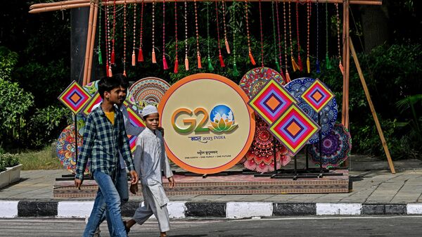 Pedestrians walk next to a G20 India summit logo ahead of its commencement in New Delhi on September 3, 2023.  - Sputnik Africa