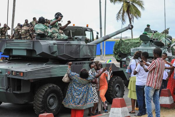 People wave and take pictures with men in uniform, moments after the swearing-in ceremony of Brice Oligui Nguema, inaugurated as Gabon&#x27;s &#x27;interim president&#x27;, in Libreville on September 4. - Sputnik Africa