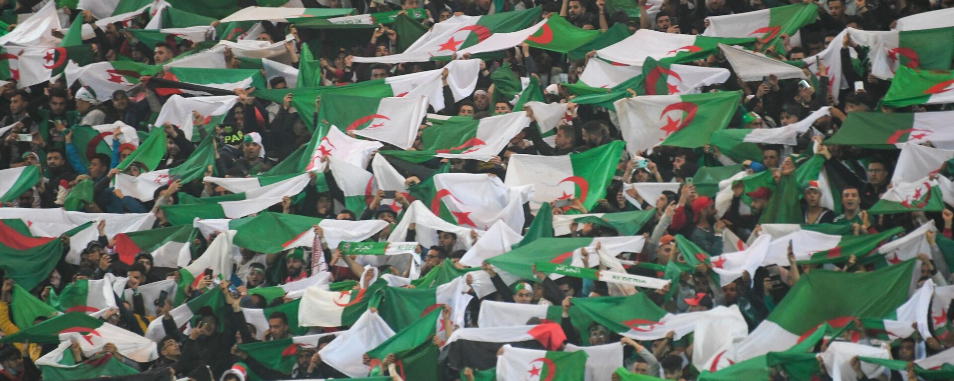 Algeria's fans wave flags during the second leg of the 2022 Qatar World Cup African Qualifiers football match between Algeria and Cameroon at the Mustapha Tchaker Stadium in the city of Blida on March 29, 2022. - Sputnik Africa, 1920, 07.09.2023