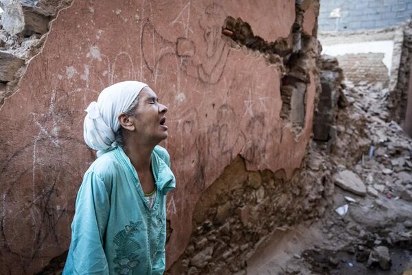 A woman reacts standing infront of her earthquake-damaged house in the old city in Marrakesh on September 9, 2023. A powerful earthquake that shook Morocco late September 8 killed more than 600 people, interior ministry figures showed, sending terrified residents fleeing their homes in the middle of the night.  - Sputnik Africa