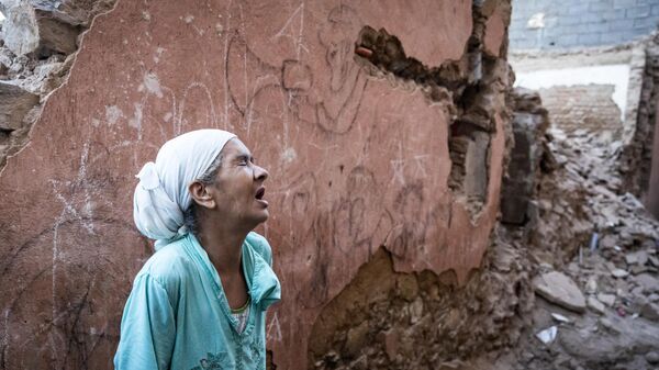 A woman reacts standing infront of her earthquake-damaged house in the old city in Marrakesh on September 9, 2023. A powerful earthquake that shook Morocco late September 8 killed more than 600 people, interior ministry figures showed, sending terrified residents fleeing their homes in the middle of the night. - Sputnik Africa