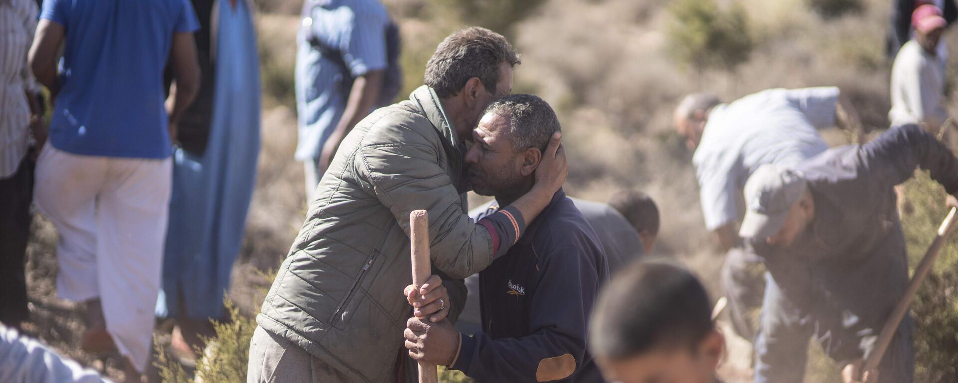 People comfort each other while digging graves for victims of the earthquake, in Ouargane village, near Marrakech, Morocco, Saturday, Sept. 9, 2023. A rare, powerful earthquake struck Morocco, sending people racing from their beds into the streets and toppling buildings in mountainous villages and ancient cities not built to withstand such force.  - Sputnik Africa, 1920, 10.09.2023