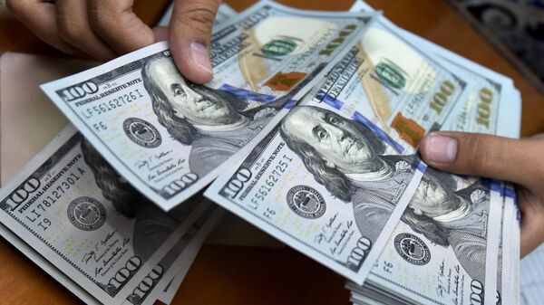 A money changer counts US dollar banknotes for customers. - Sputnik Afrique