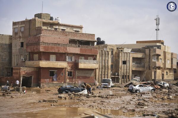 Сars and rubble sit in a street in Derna. - Sputnik Africa