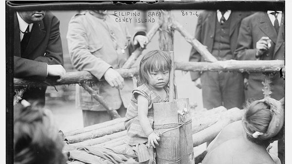A little Filipino girl sitting on top of a wooden pole in the Coney Island Zoo - Sputnik Africa