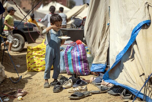 A young boy eats his meal in front of tent at a temporary camp set up for earthquake survivors, in Amizmiz in Morocco&#x27;s High Atlas mountain range on September 14, 2023. - Sputnik Africa