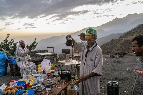 63-year-old Ahmed Hafidi (R) provides free food to the eartquake survivors near his destroyed guest house in the Atlas Mountains range in  in Al-Haouz province on September 14. - Sputnik Africa