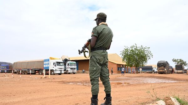 A Niger's police officer stands guard next to some of the 300 trucks mainly loaded with food that arrived from Burkina Faso in Niamey on August 21, 2023. - Sputnik Africa