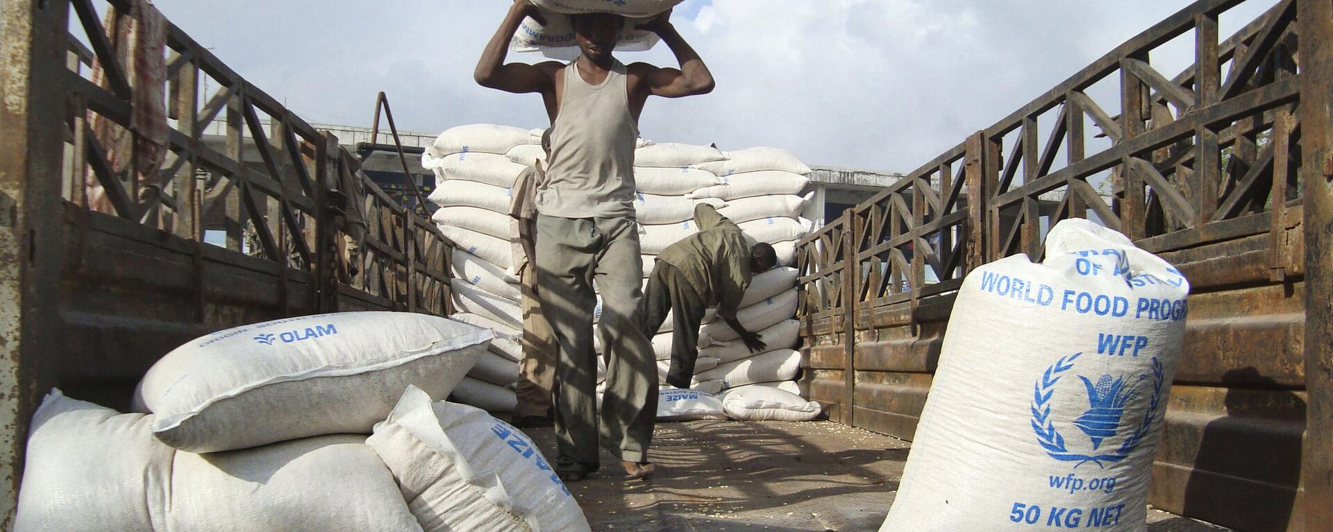 Laborers unload a consignment of food aid from the World Food Programme (WFP) in Mogadishu, Somalia, on Monday, Aug. 8, 2011. - Sputnik Africa, 1920, 18.09.2023