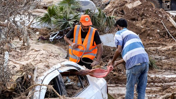 Men prepare a car for evacuation in the city of Derna, Libya - Sputnik Africa