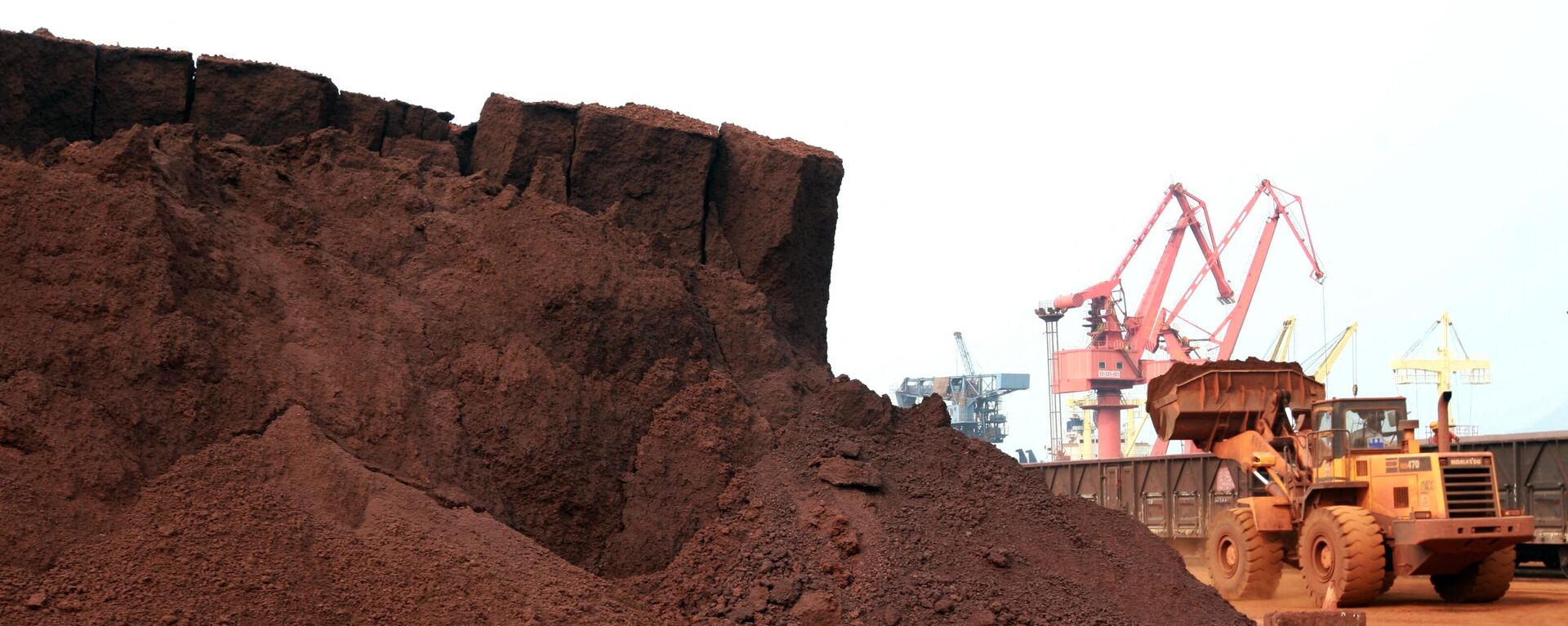 
In a picture taken on September 5, 2010 a man driving a front loader shifts soil containing rare earth minerals to be loaded at a port in Lianyungang, east China's Jiangsu province, for export to Japan.  - Sputnik Africa, 1920, 24.09.2023