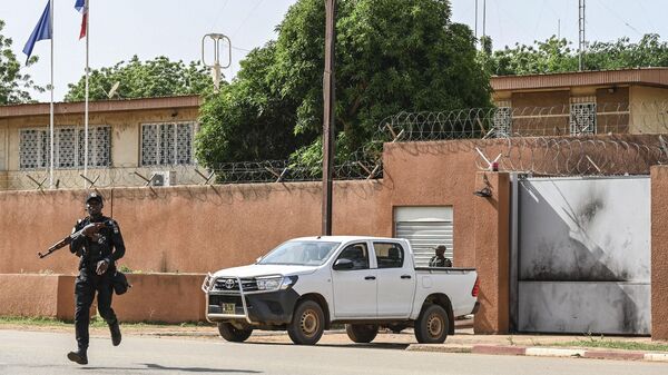 An officer of the Niger national Police crosses the street in front of the French Embassy in Niamey on August 28, 2023 - Sputnik Africa