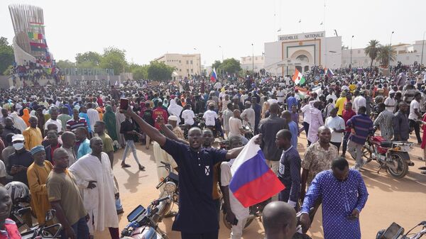 Nigeriens, some holding Russian flags, participate in a march called by supporters of coup leader Gen. Abdourahmane Tchiani in Niamey, Nige - Sputnik Africa