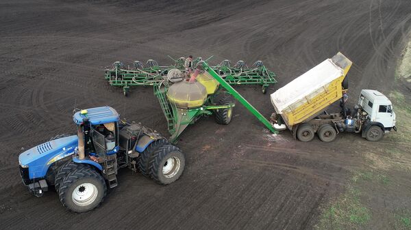 Russian farmers load fertilizer into a sowing machine in Krasnoyarsk region, Russia. - Sputnik Africa