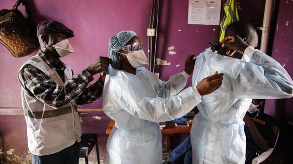 Medical staff help each other put on protective equipment before dealing with patients with non-coronavirus related issues at the Medecins Sans Frontieres (Doctors without Borders) clinic in the Mathare slum of Nairobi, Kenya Thursday, May 28, 2020.  - Sputnik Africa