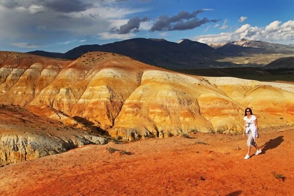 A woman in the Kyzylсhin valley in the Chuya Steppe of the Altai Republic. The high mercury content in the rock gives it a reddish tint. - Sputnik Africa