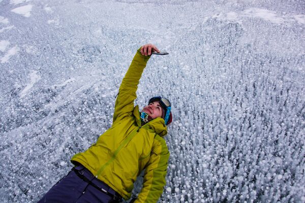 A woman takes a photo on Lake Baikal. - Sputnik Africa