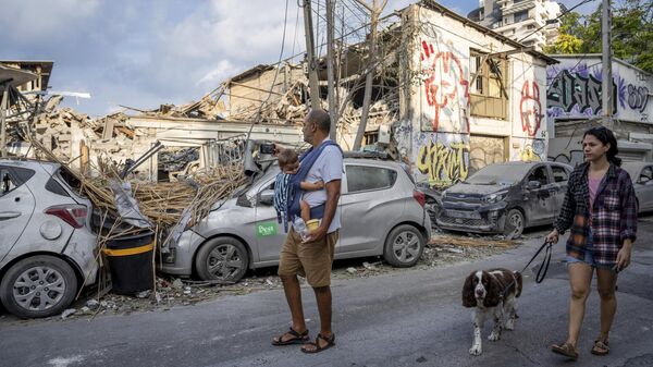 Israelis inspect the rubble of a building a day after it was hit by a rocket fired from the Gaza Strip, in Tel Aviv, Israel, Sunday, Oct. 8, 2023.  - Sputnik Africa