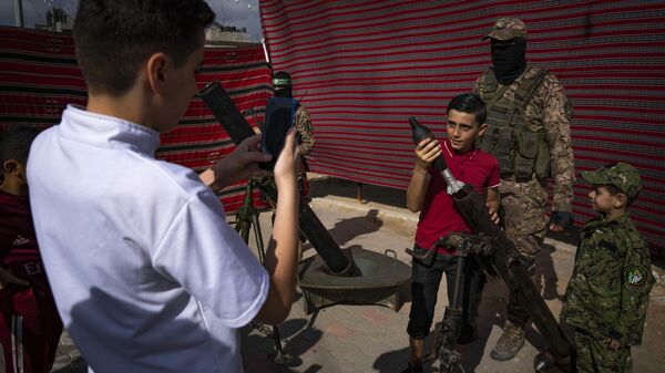 Palestinian children pose with weapons and ammunition at an arms - Sputnik Africa