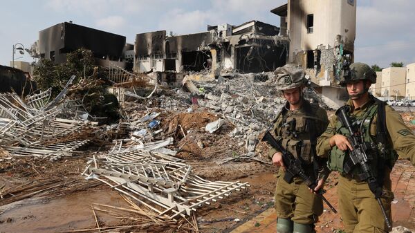 Soldiers walk in front of an Israeli police station that was damaged during battles to dislodge Hamas militants who were stationed inside, on October 8, 2023.  - Sputnik Africa