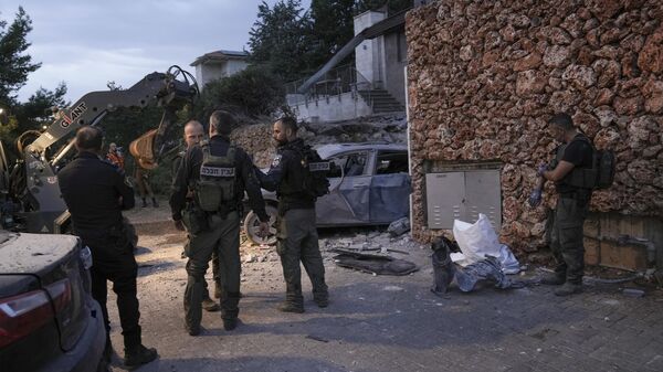 Israeli security forces inspect a damaged house after it was hit by a rocket fired from the Gaza Strip, in Har Adar settlement near Jerusalem, Monday, Oct. 9, 2023. - Sputnik Africa