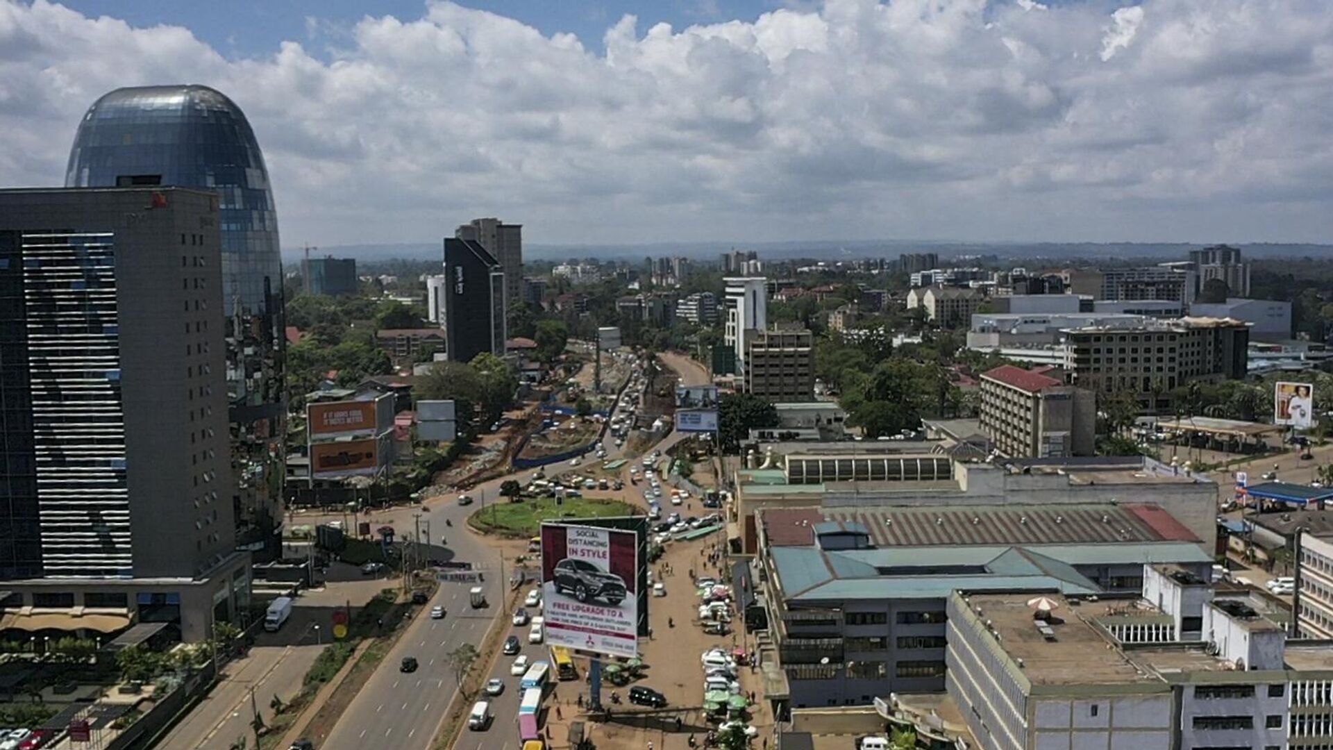 An aerial view shows traffic flowing past the area where an iconic, century-old fig tree is placed after a presidential declaration was issued to save the centenary tree from being cut down to make way for a Chinese-funded highway in Westlands district of Nairobi, Kenya on November 12, 2020.  - Sputnik Africa, 1920, 10.10.2023