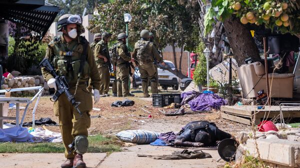Des soldats israéliens près du corps d'un militant palestinien à Kfar Aza - Sputnik Afrique