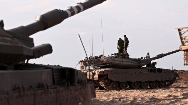 Israeli troops and tanks gather in a field near the kibbutz Beeri in southern Israel on October 14, 2023, - Sputnik Africa