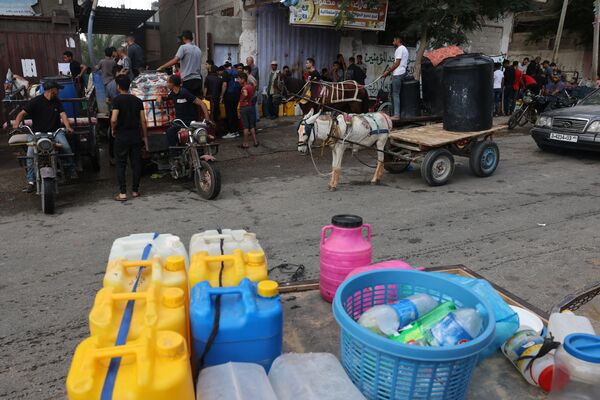 Palestinians line up to refill on water at the Rafah refugee camp in the southern Gaza Strip, on October 14, 2023.  - Sputnik Africa