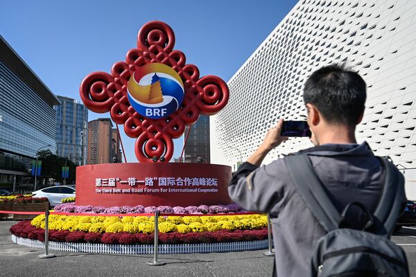 A man takes photos of an installation of the Belt and Road Forum. - Sputnik Africa