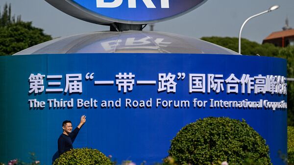 A man poses next to the installation of the One Belt, One Road forum in Beijing, China - Sputnik Africa