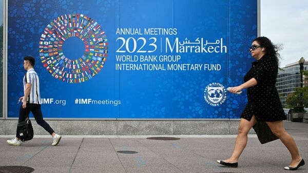 Pedestrians walk past a billboard announcing the World Bank Group and International Monetary Fund annual meetings, on the side of the International Monetary Fund headquarters in Washington DC on October 5, 2023.  - Sputnik Africa
