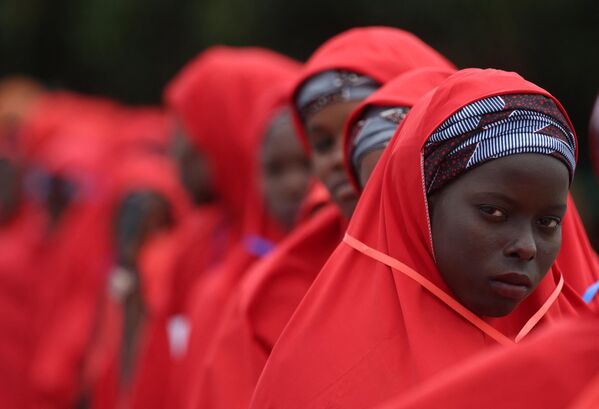A bride dressed in red robe, looks on at the venue of a wedding reception at the Kano state governor&#x27;s office after taking part in a mass wedding at the central mosque in Kano city, Kano State, Nigeria on October 14, 2023. The mass wedding is sponsored by the Kano State government in Nigeria to help widows and divorcees get remarried.  - Sputnik Africa