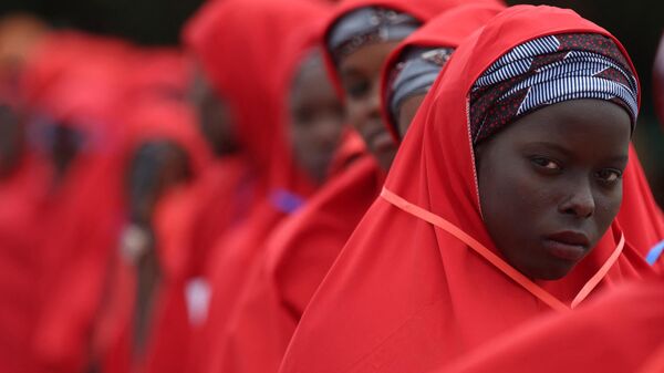 A bride dressed in red robe, looks on at the venue of a wedding reception at the Kano state governor's office after taking part in a mass wedding at the central mosque in Kano city, Kano State, Nigeria on October 14, 2023. - Sputnik Africa