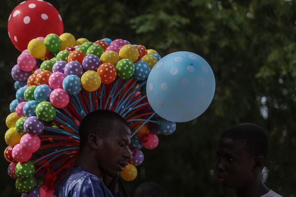 A Nigerian balloon vendor displays his wares at the celebration of the wedding of 1800 couples at Kano Central Mosque, Kano State, Nigeria on October 13, 2023.  - Sputnik Africa