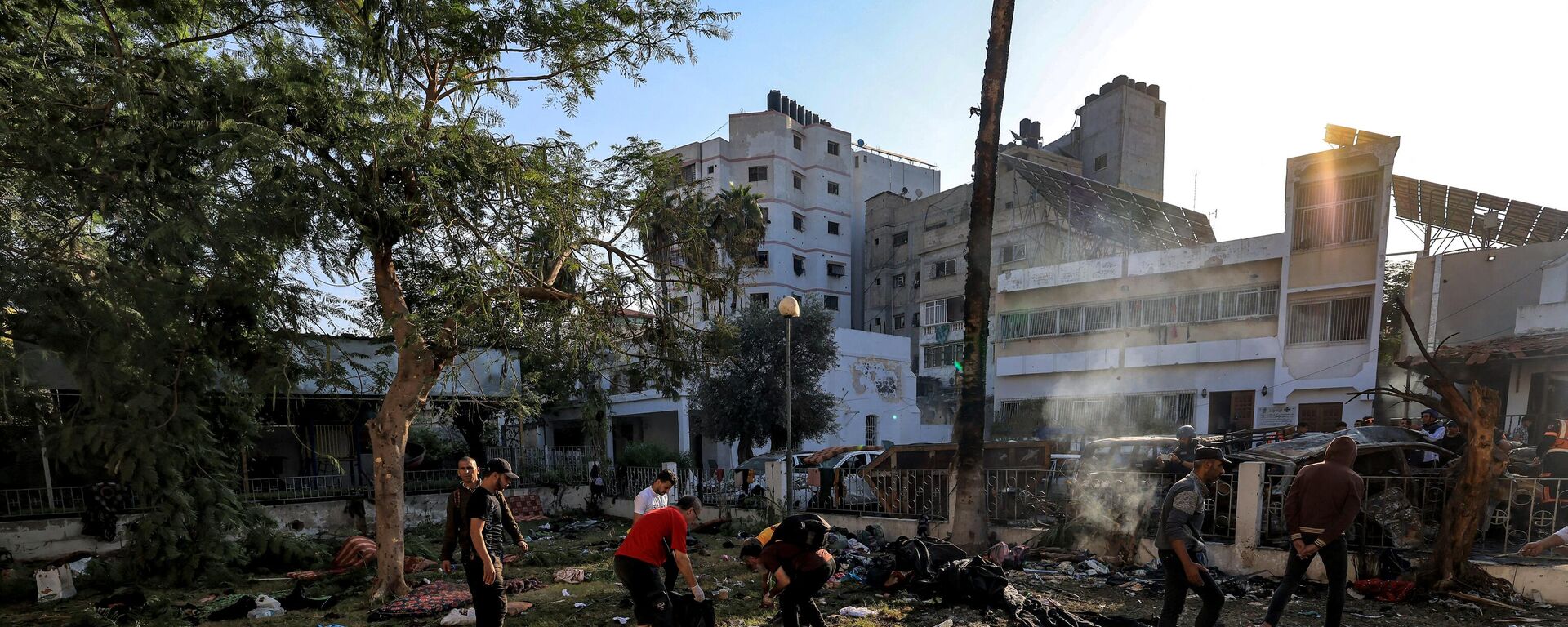 People search through debris outside the site of the Ahli Arab hospital in central Gaza on October 18, 2023 in the aftermath of an overnight blast there.  - Sputnik Africa, 1920, 18.10.2023