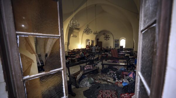 Палестинцы осматривают повреждения в церкви, которую люди использовали в качестве убежища, при больнице аль-Ахли в городе Газа - Sputnik Africa